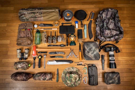 Camouflage military themed camping or bugout bag gear flat lay